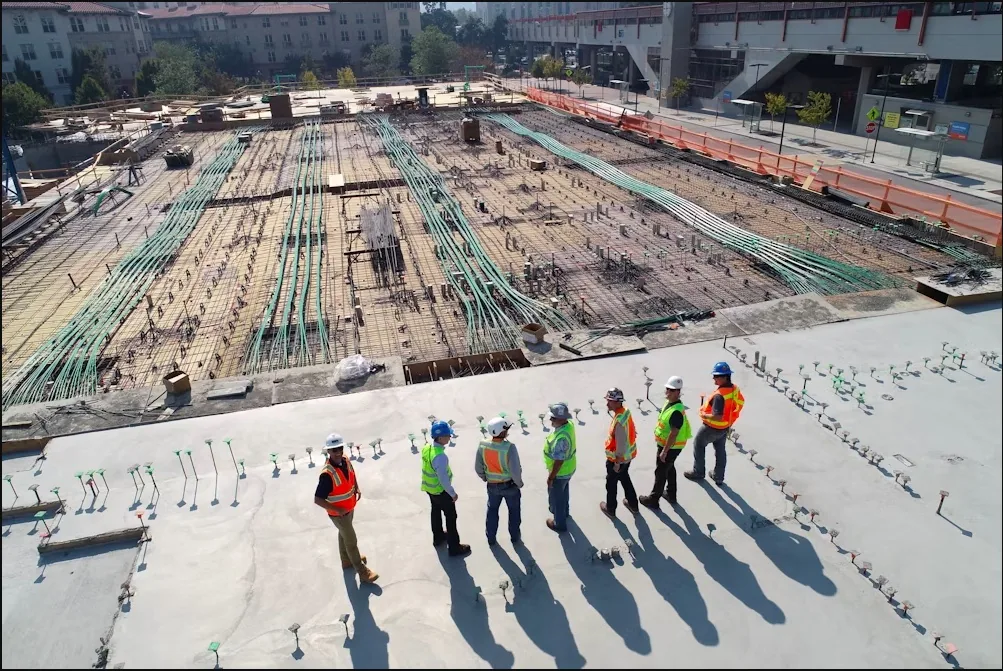 Project team in hard hats and safety vests walking a large construction site, illustrating how to choose a paving contractor in Spokane, WA